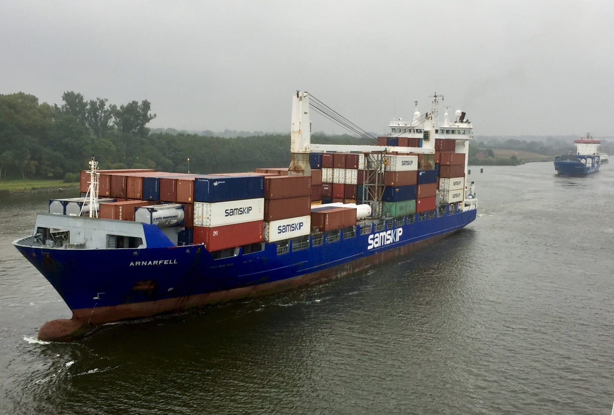 der Blick vom Kreuzfahrtschiff "Europa 2" im Morgennebel auf entgegenkommende Feederschiffe - hier im Vordergrund das blaue Schiff Arnafell, die von weiteren vier Schiffen gefolgt wird.